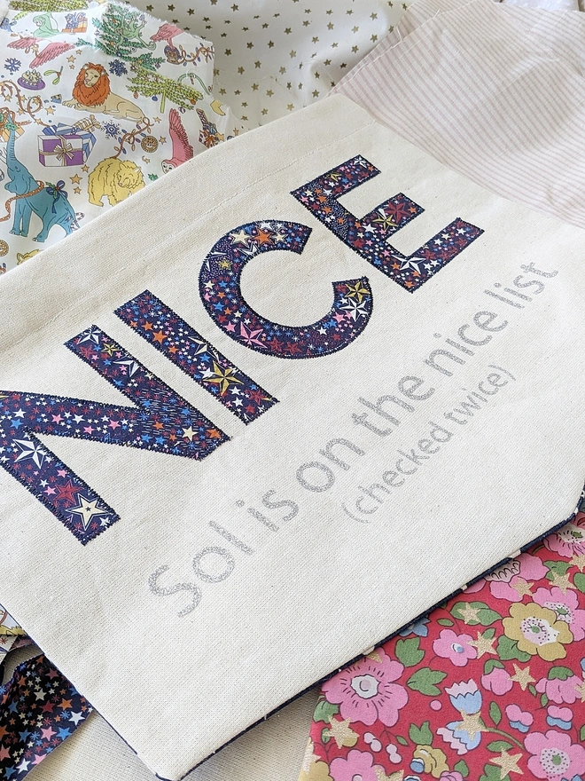 Personalised “Nice List” Christmas banner with Liberty fabric appliqué & glitter name print. Handmade festive wall hanging for kids on Santa’s nice list.