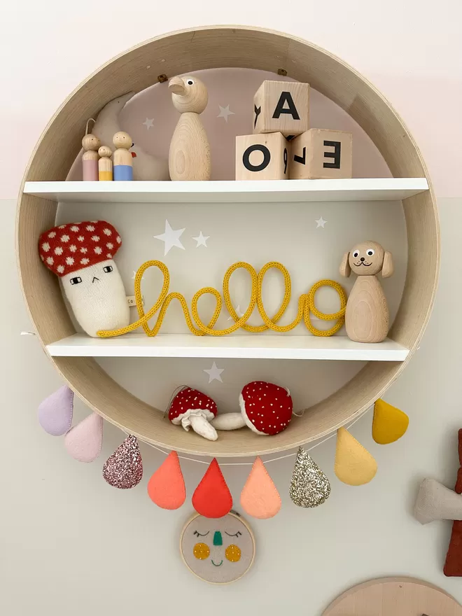 "hello" in mustard yellow decorating a shelf in a child's playroom. 