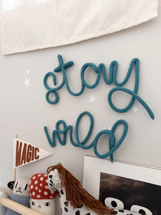 "stay wild" wall art hanging up on the wall in a bedroom for a child. 
