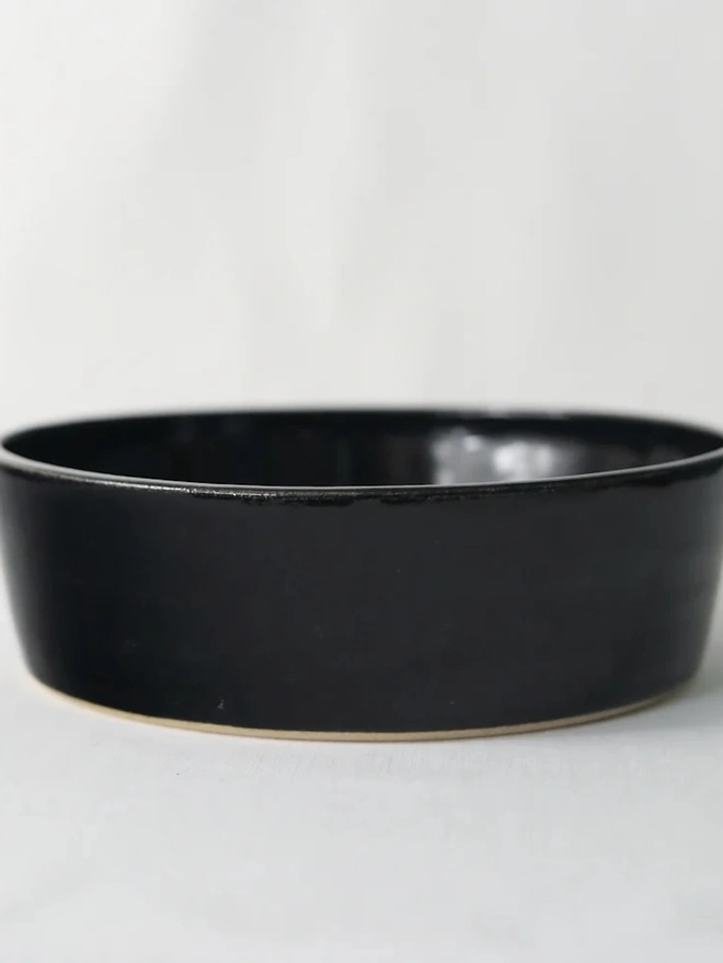 Classic Pasta Bowl, a colourful ceramic bowl sitting on a plain surface against a grey backdrop. 