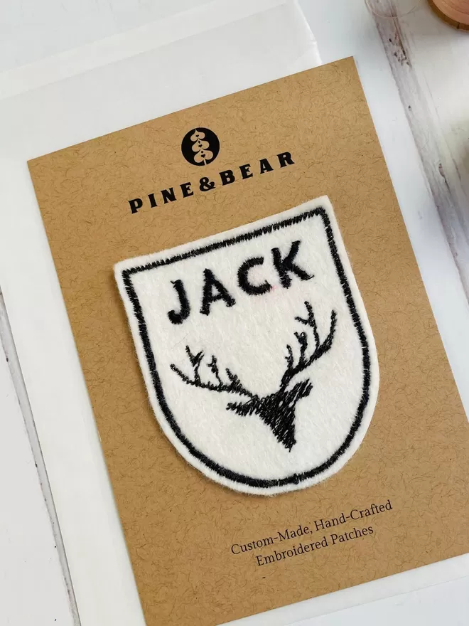 embroidered stag patch on a presentation card.