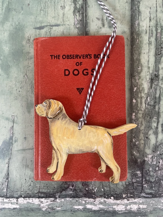 A Golden Labrador Memorial decoration placed on a red book about dogs