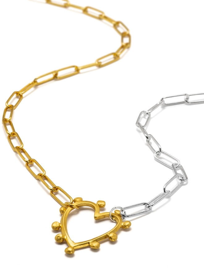 Celebrate connection with the Large Studded Heart Necklace. Featuring a textured studded heart charm suspended from a mixed metal paperclip chain, this statement necklace makes a meaningful gift or personal keepsake. Designed to stand out while remaining beautifully wearable, it’s heart jewellery with real feeling.