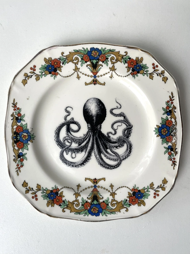 a vintage plate with ornate border, and in the centre is the vintage victorian illustration of an octopus