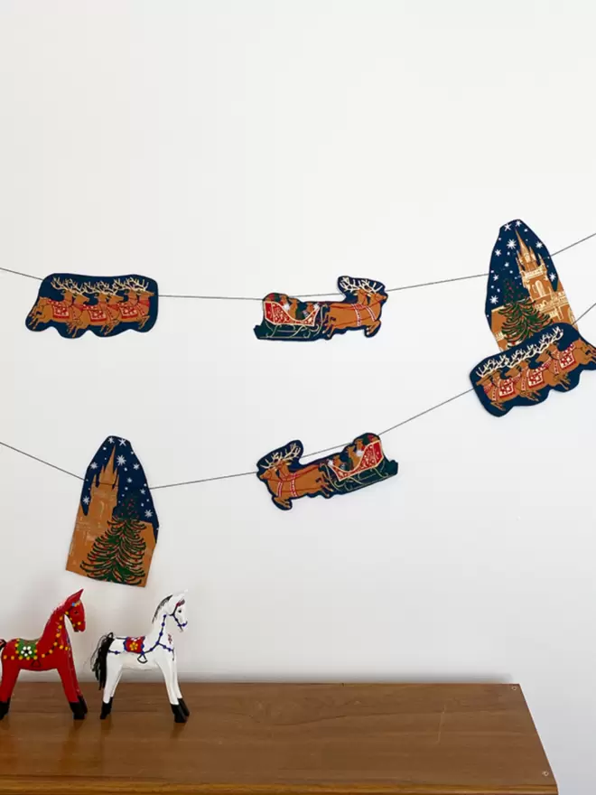 Christmas night themed garland hanging on white wal