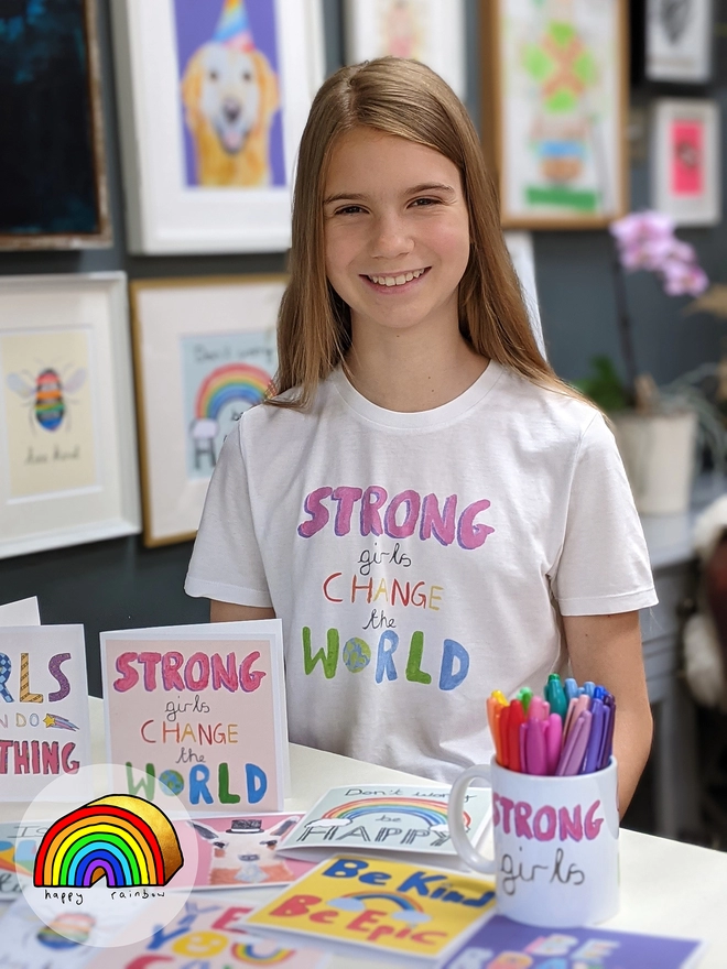 Young girl sitting with a range of kids' prints and cards