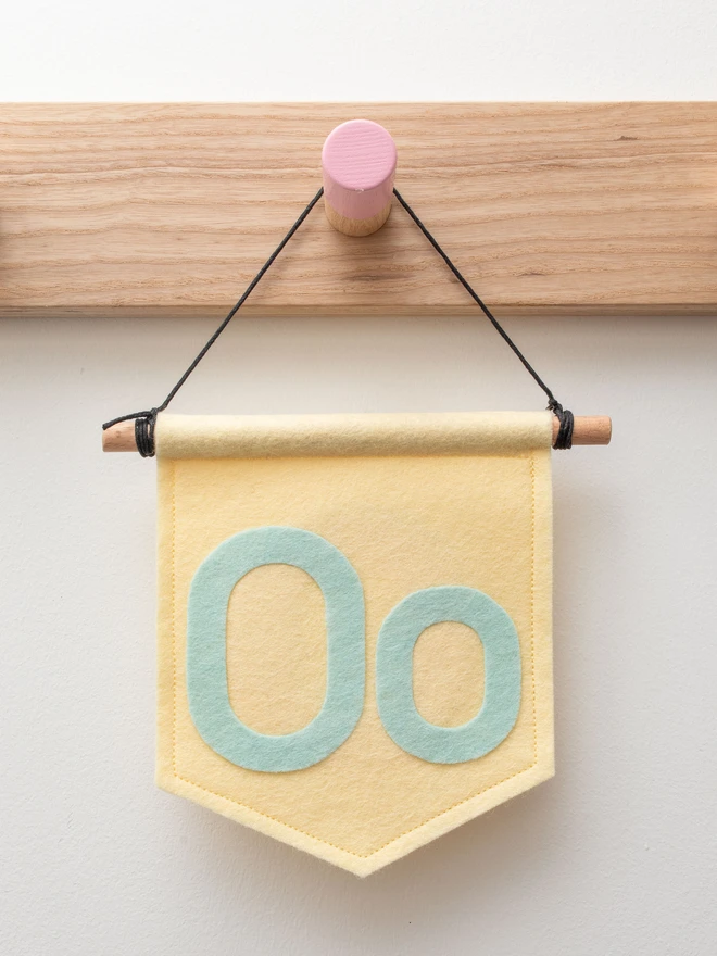 lemon coloured banner with an upper and lowercase "O" in pale mint felt