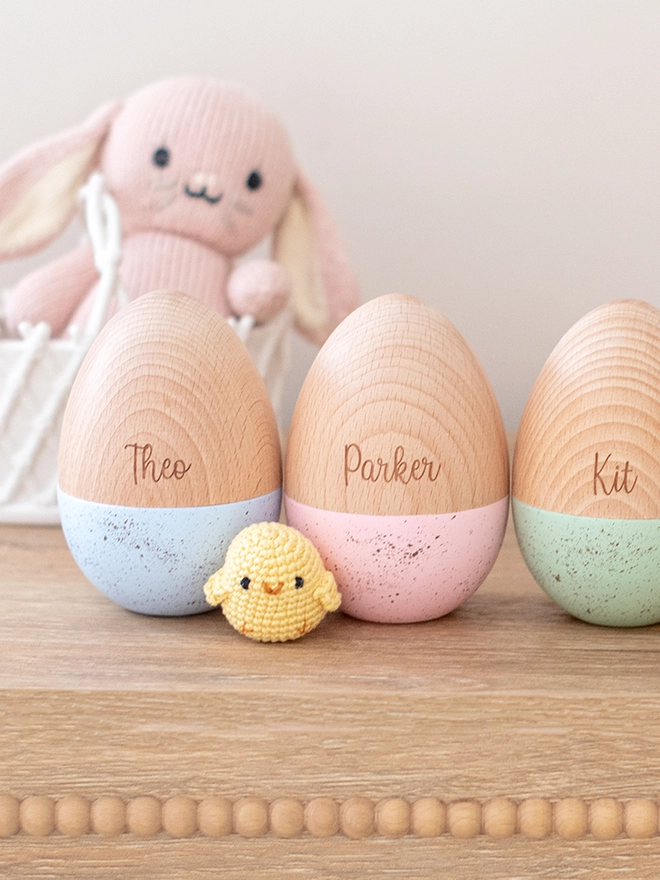A set of three wooden eggs with a speckled paint finished. In colours sky, pink and mint with the names Theo, Parker and Kit.
