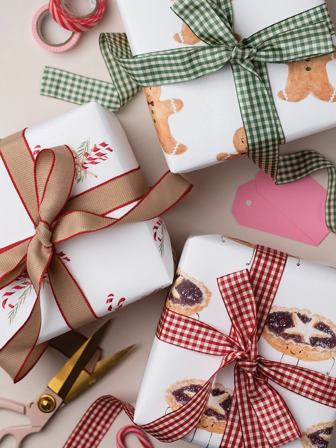 Three beautifully wrapped Christmas Gifts using Mince Pie Gift Wrap, Candy Cane Wrapping Paper and Mince Pie Gift Wrap.  Each gift has been tied with a beautiful contrast bow.