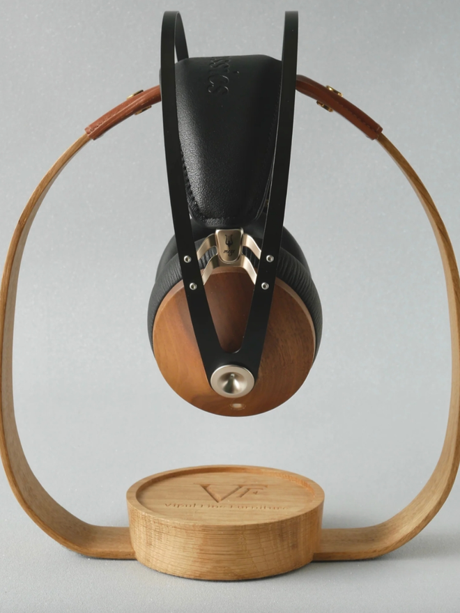 The Band Wooden Headphone Stand. A side view of a Natural headphone stand with Tan leather.