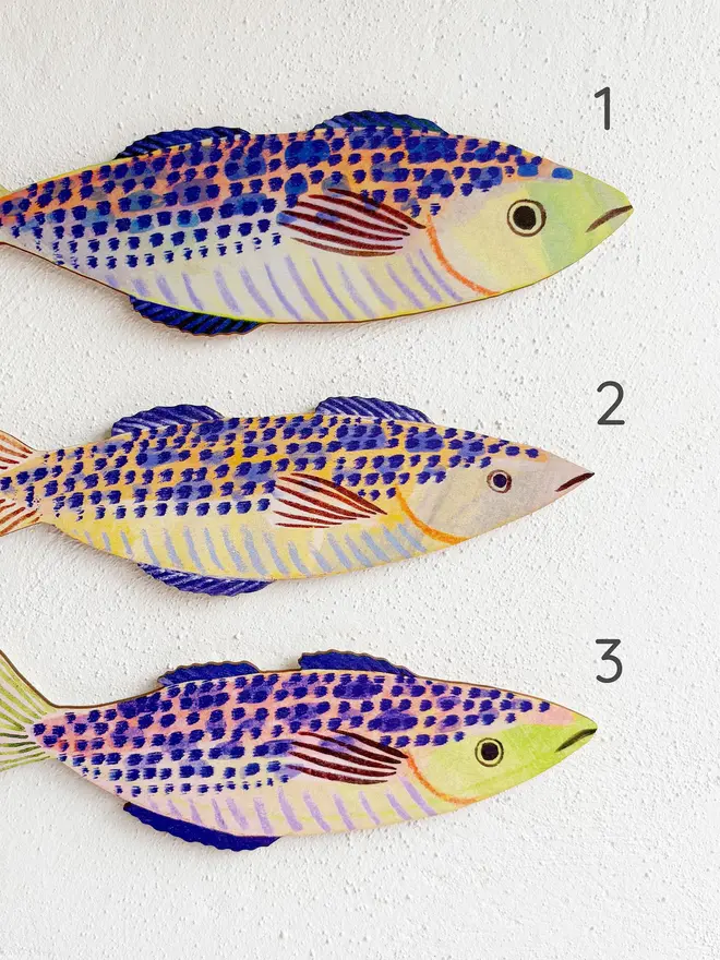 blue wooden mackerel wall decorations. wooden mackerel labelled with numbers for identification of different designs.