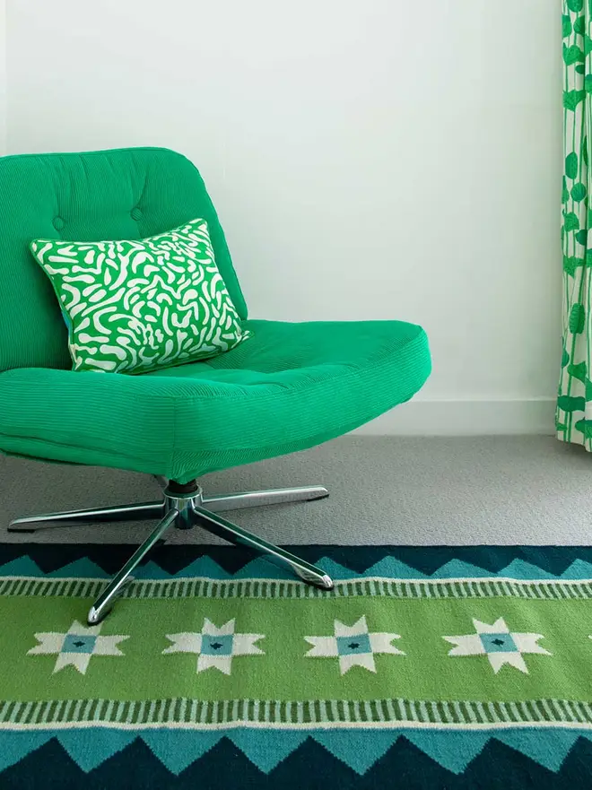Victoria Flatweave Runner Rug, a colourful rug sitting in a decorated room. It is accompanied by other colourful household items. 