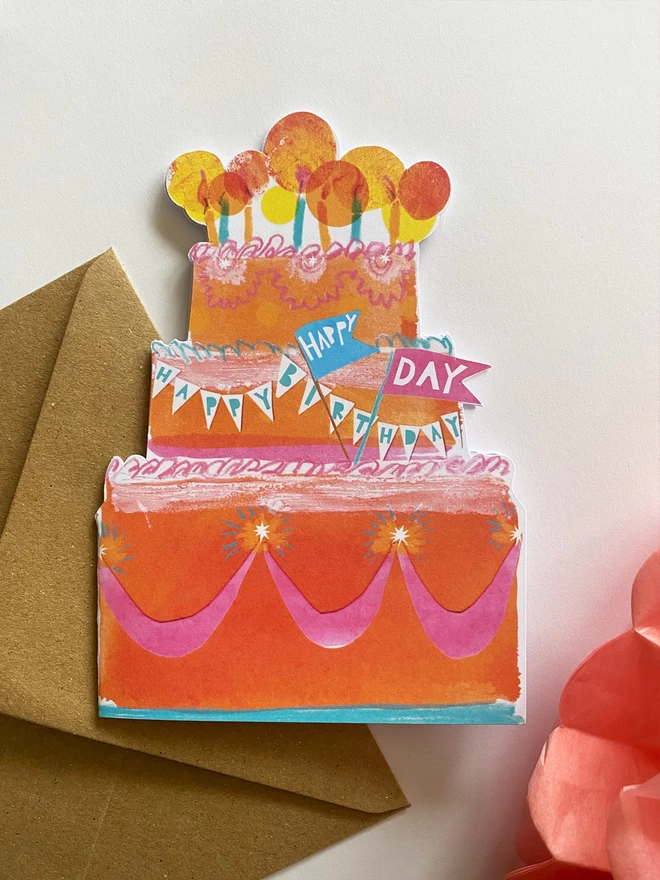 Happy Birthday Cake custom-shaped illustrated card by Esther Kent, in the shape of an extravagent 80s oragne, pink and turqoise layered v=cake, topped with glowing candles