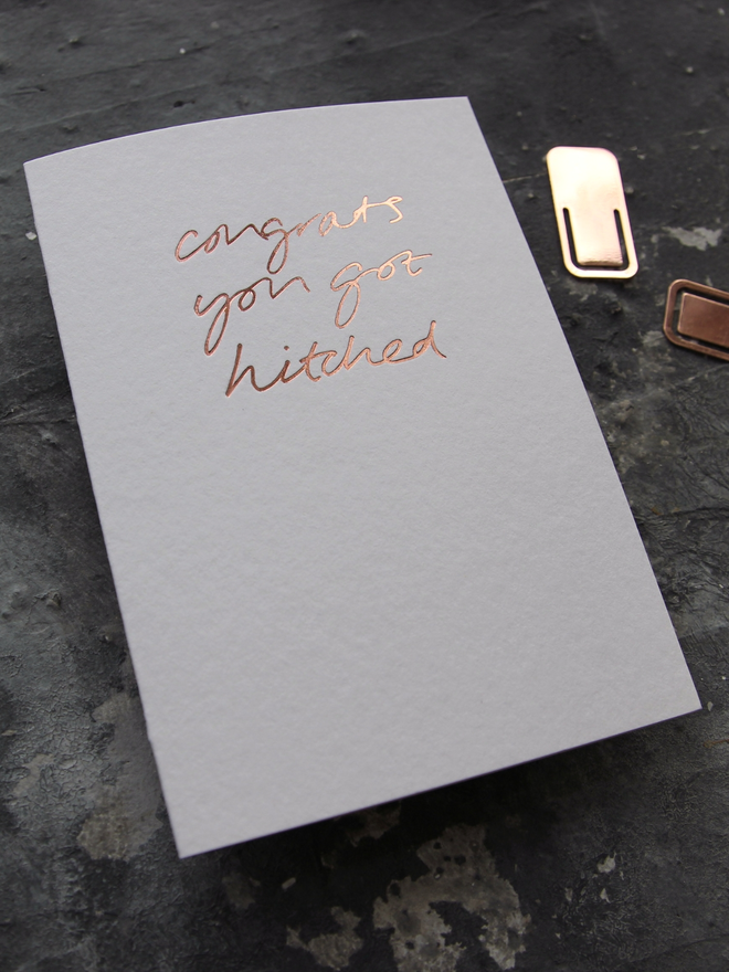 hand foiled card with a handwritten phrase that says Congrats You Got Hitched