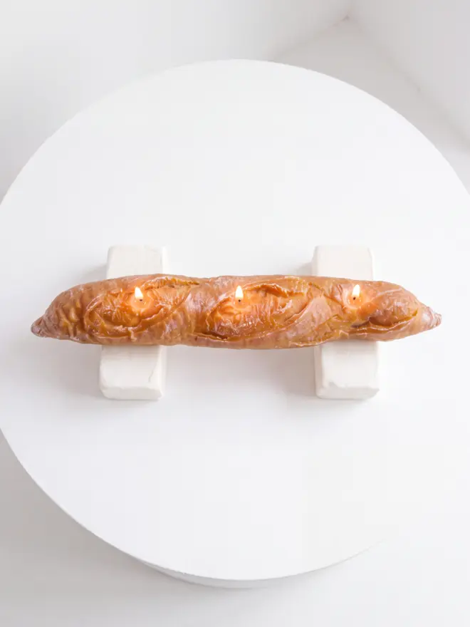 lit Baguette candle aerial view on blocks of white butter