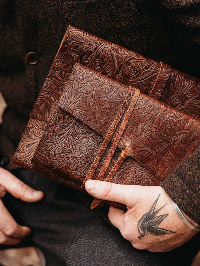 make your own leather journal. two brown leather journal held in hands.
