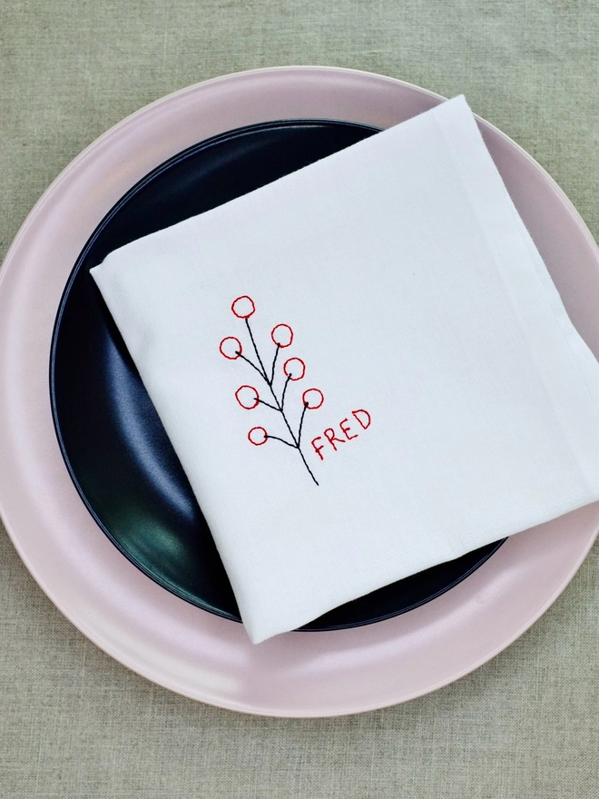 Berry embroidered napkin with custom name in red block text, cotton Christmas napkin