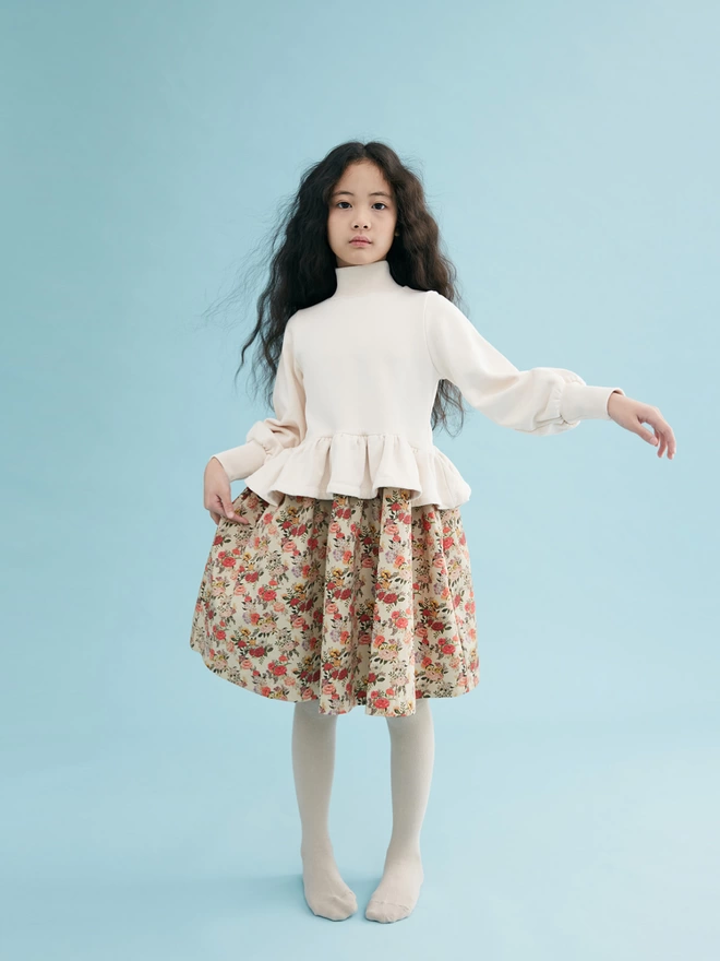 Cotton brushed back sweat to bodice and a cotton sateen dress in our own developed print to skirt. Featuring rib to the neck and deep cuffs, balloon sleeves and a fully gathered peplum.