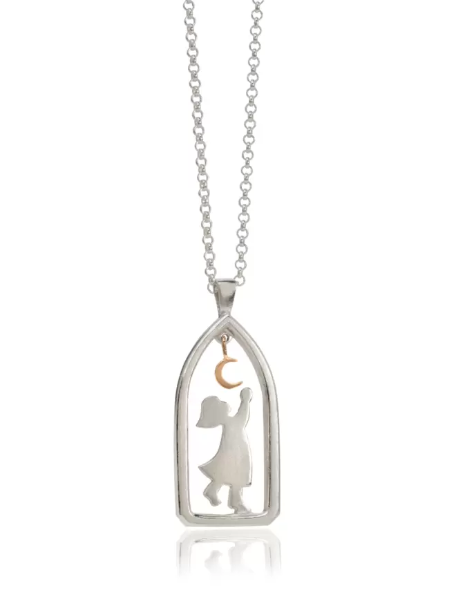 Silver pendant suspended on fine chain, inside arch shaped frame is a sillouhete of a child reaching towards a hanging gold crescent moon