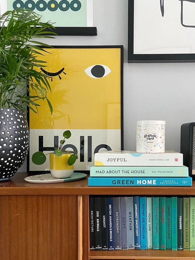 bold yellow wall print with word Hello propped on a shelf