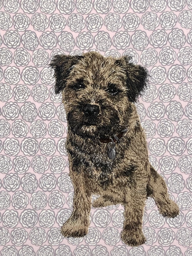 embroidered pet portrait (detail) of a scruffy terrier, on a pink Liberty background