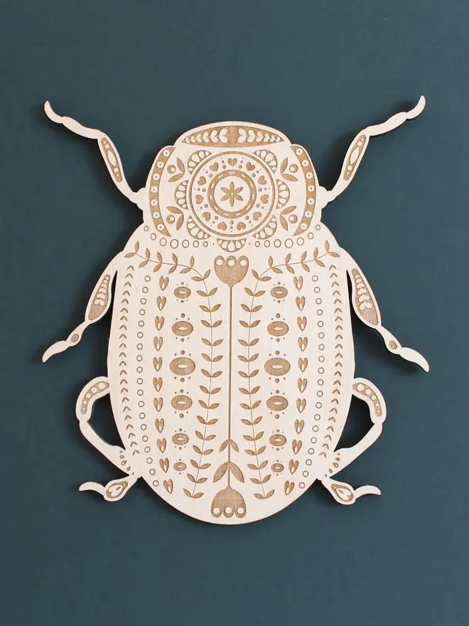 Folk Art Beetle Wall Hanging, wooden insect decoration hanging on a wall. 