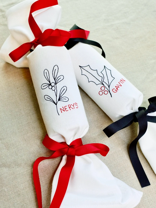 Personalised name fabric Christmas crackers with mistletoe and holly designs and red and black ribbons