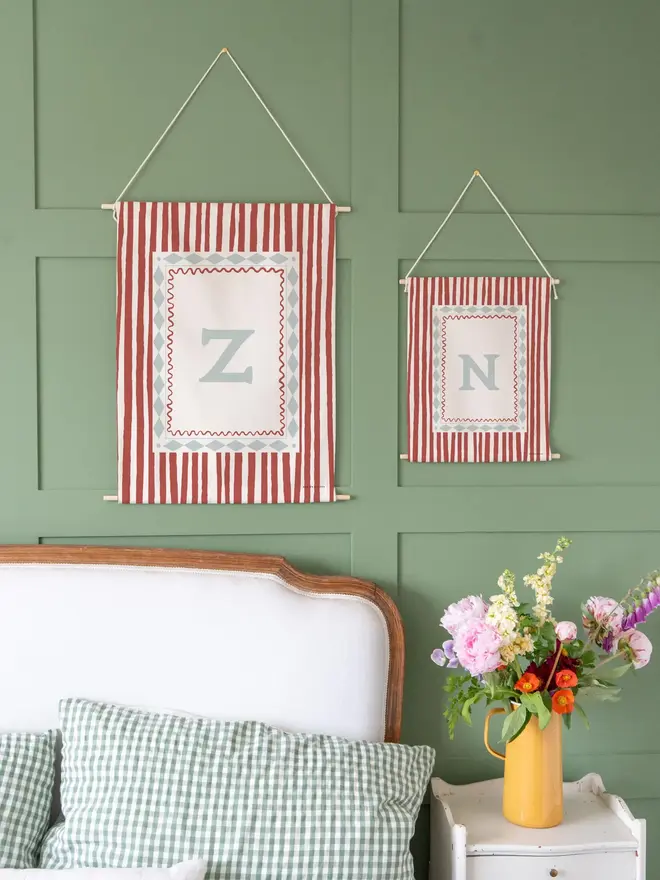 Stripe Initial Fabric Banner, hanging on a green wall. 