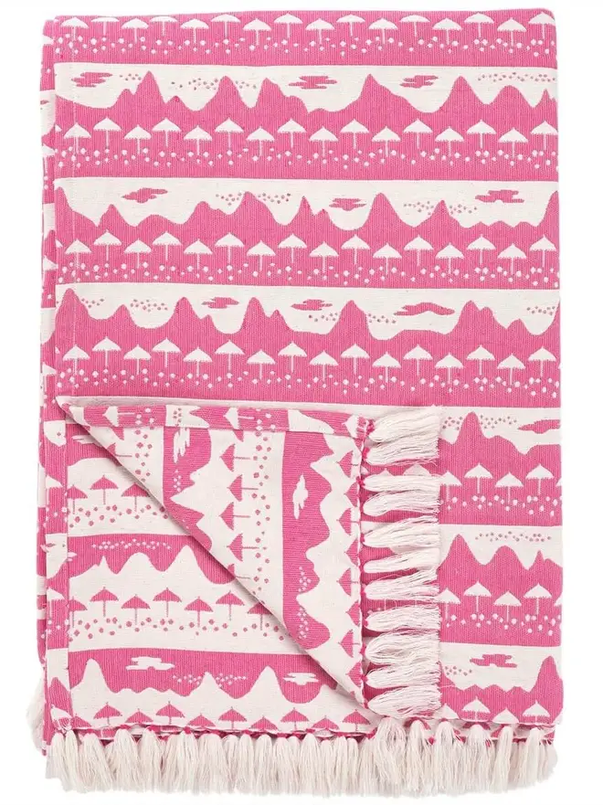 Pink Belle Mare Woven Throw, a pink throw sitting on a white surface. 