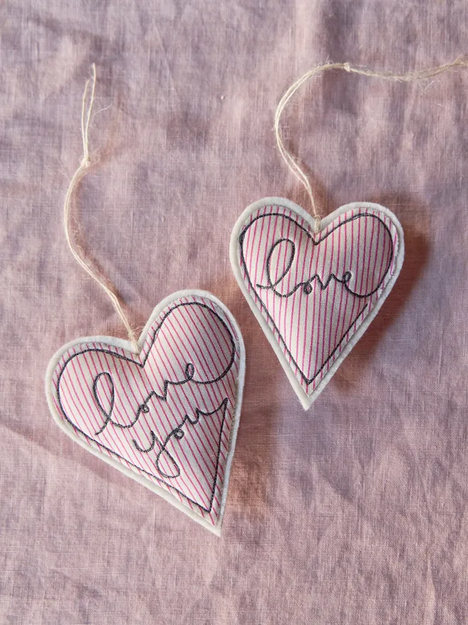 Love you embroidered Valentine's Day heart. A heart shaped hanging decoration in a red striped fabric with the words I love you embroidered on the front.