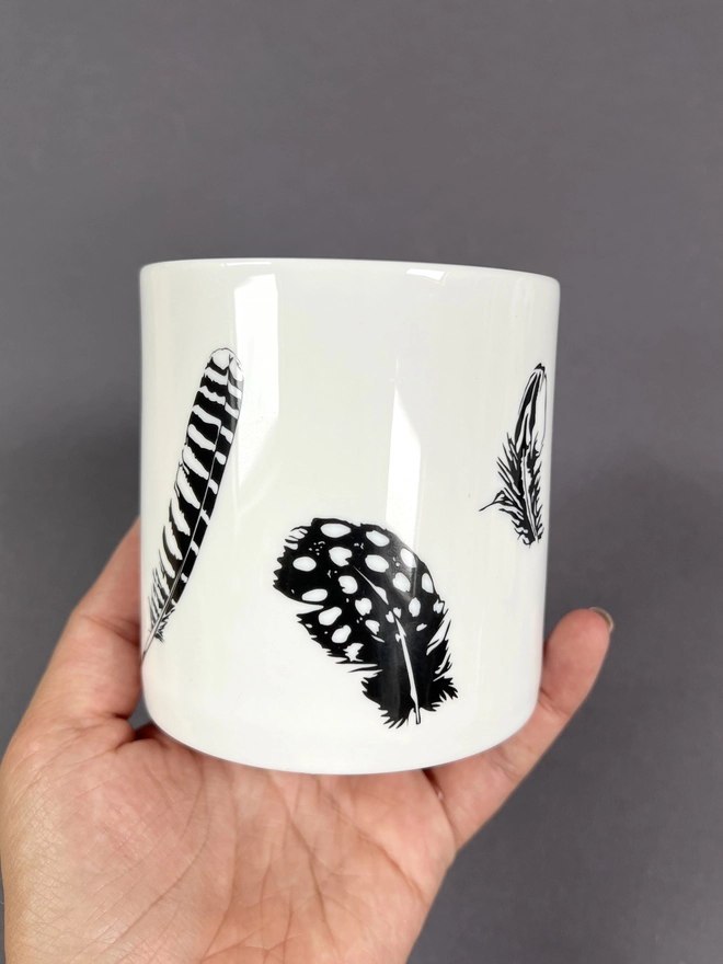 Image of the black and white multi feather mug showing the Tawny owl and Guinea fowl feathers