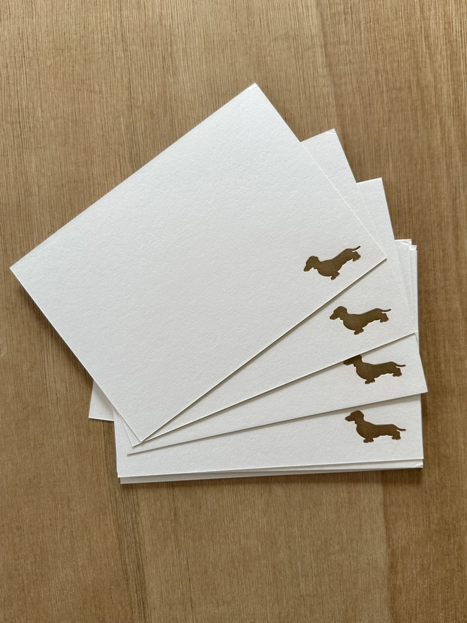 Dachshund notecards with golden dachshund in bottom corner, in a pile spread out