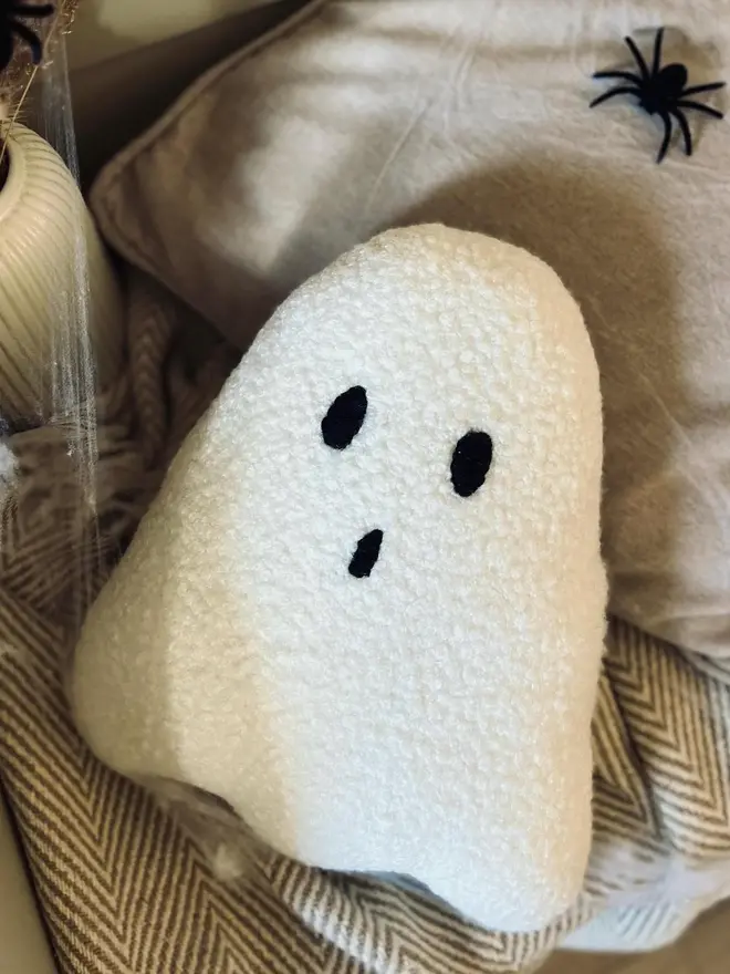 boucle ghost pillow. a white cushion in the shape of a ghost.
