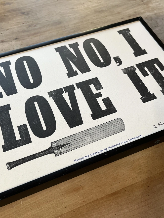 Picture of Letterpress print 'No No, I Love It' Oblique angle on wooden table showing side profile of possible effect of framing