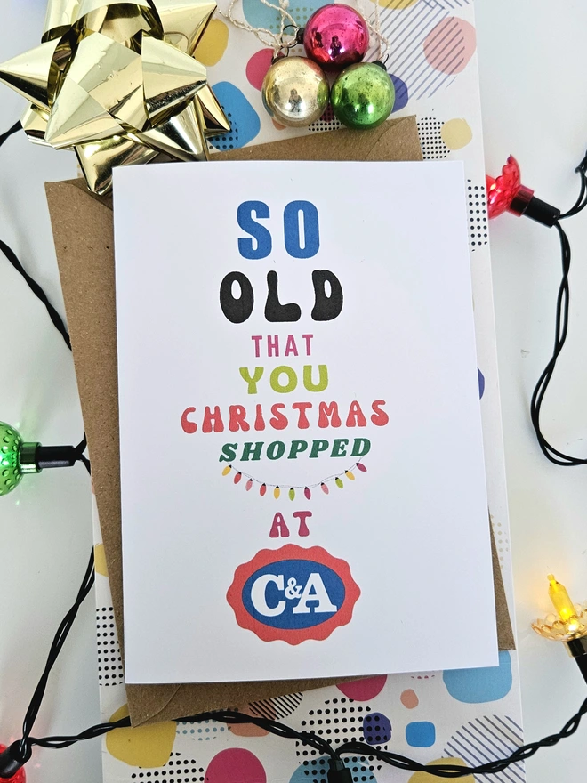 A photograph of the front of a humorous A6 greeting card illustrated using brightly coloured text and the retro shop logo. The text says so old you Christmas shopped at C&A