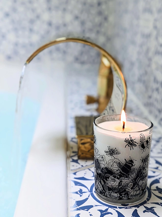 bee free oats & honey  charity candle in a reusable decorated glass in a bathroom setting