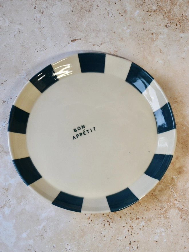 Handmade ceramic plate with teal and cream striped rim — “Bon Appétit” text in centre