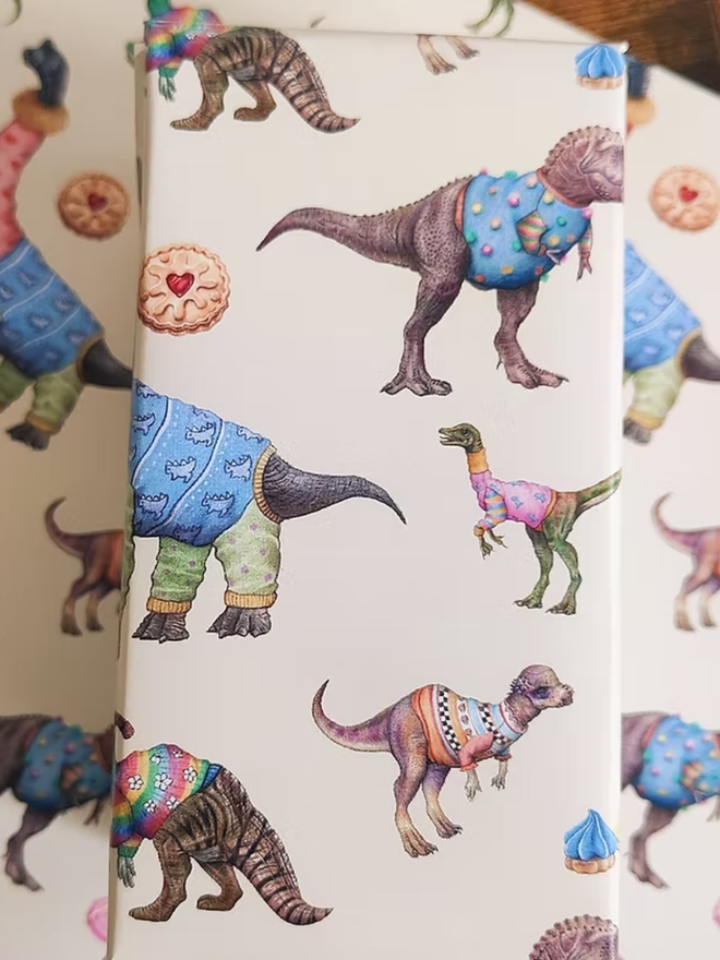 illustrated dinosaurs and biscuits wrapping paper sheets. a sheet of cream wrapping paper featuring illustrated dinosaurs and biscuits.