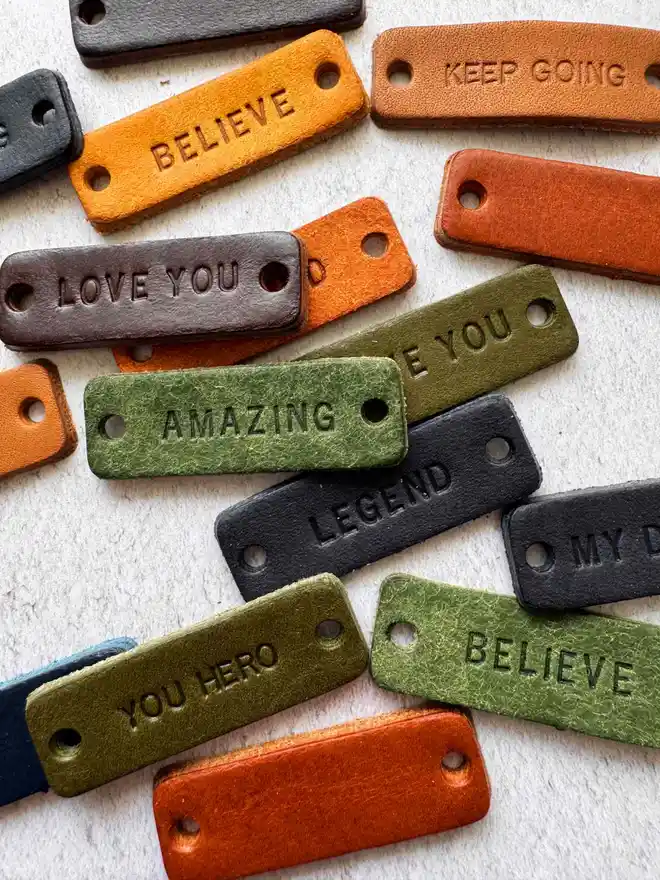 Lots of leather trainer labels with various motivational words on them