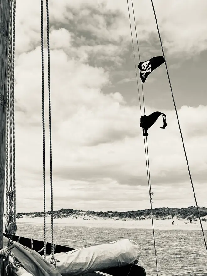 a photo of a sailing boat with an amazons pennant flying from the mast.