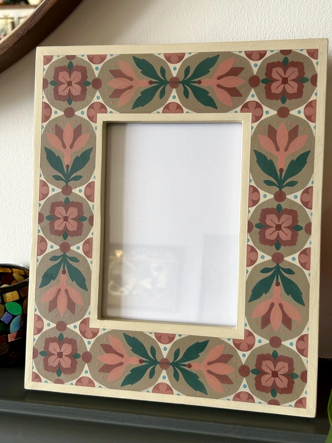 Folk art inspired hand painted decorated flower patterned photo frame painted in pinks, green, cream and light brown