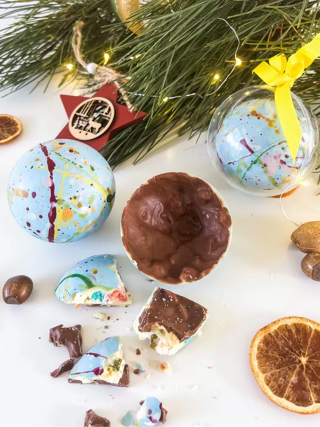 chocolate ornaments on a table with orange slices and pine needles