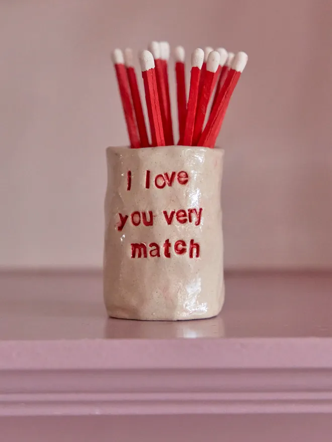Tall ceramic match holder with the phrase 'I love you very match' stamped into it 