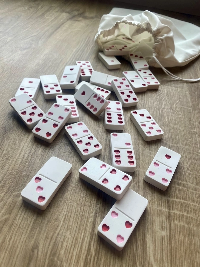 Handmade Valentines And Colourful Jesmonite Dominoes, a group of colourful dominoes on a wooden surface. These have hearts on them. 