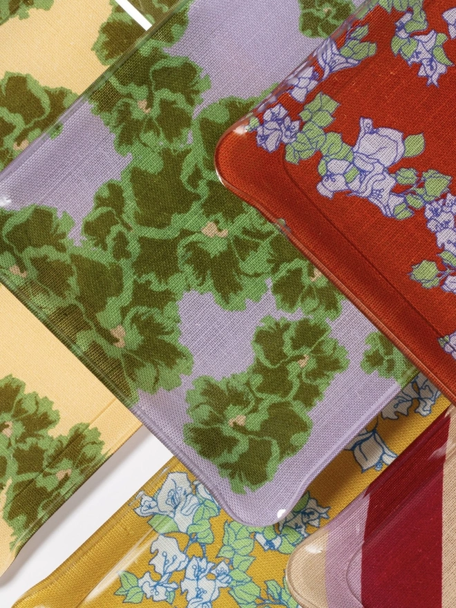 Acrylic Midi Tray, a group of colourful and patterned trays sitting on a plain surface. 