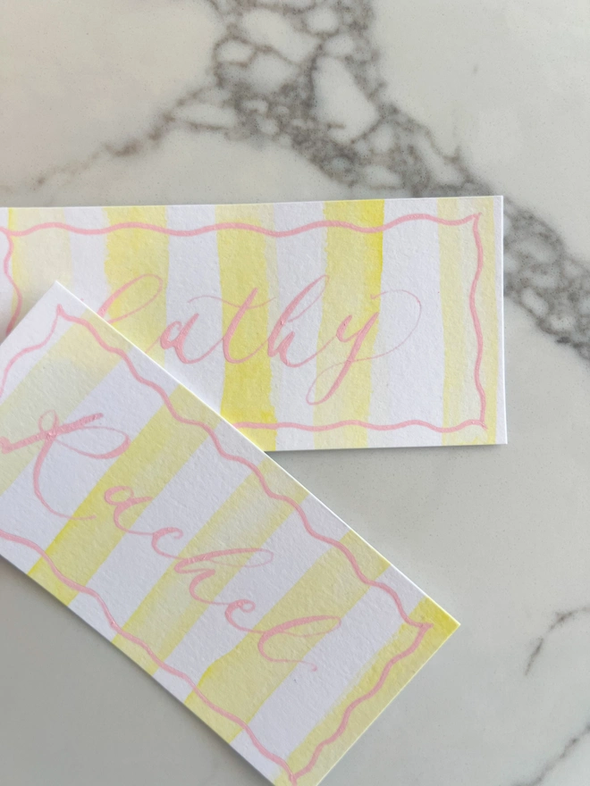 Personalised calligraphy event place cards, yellow striped coloured place cards with pink calligraphy name