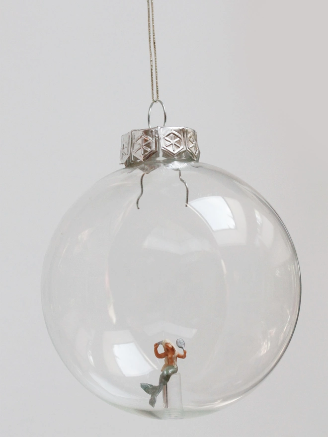 Miniature figure of a mermaid in a glass Christmas bauble