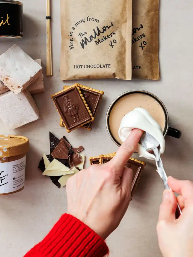 The-Mallow-Makers-close-up-of-fingers-scooping-marshmallow-fluff-onto-hot-chocolate