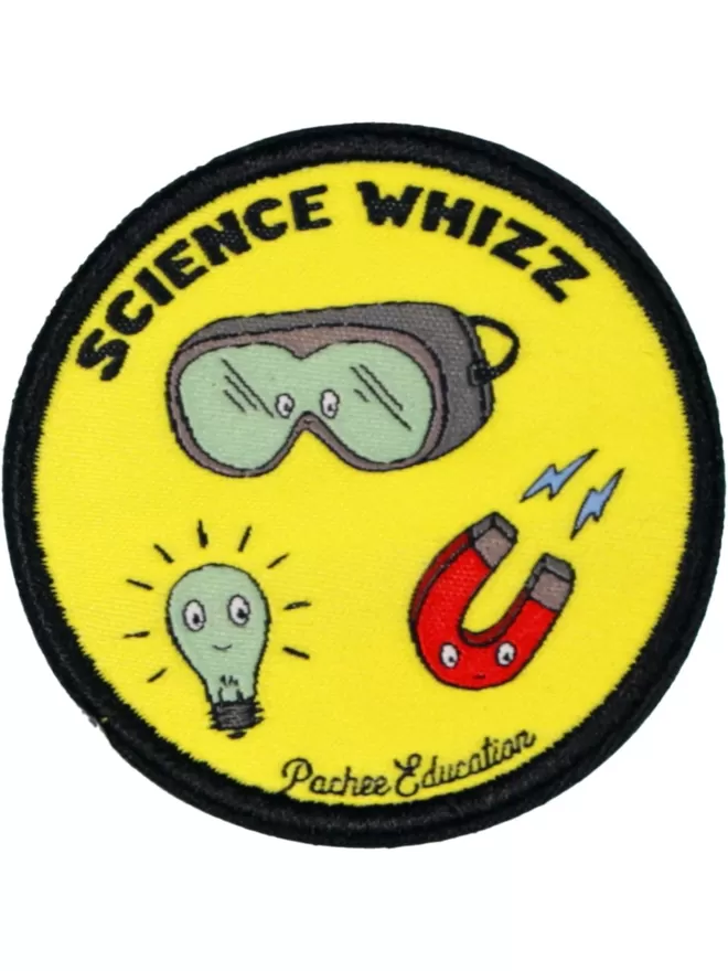A yellow circular patch with science whizz written at the top in bold lettering. Beneath are goggles, a lightbulb, and a magnet.