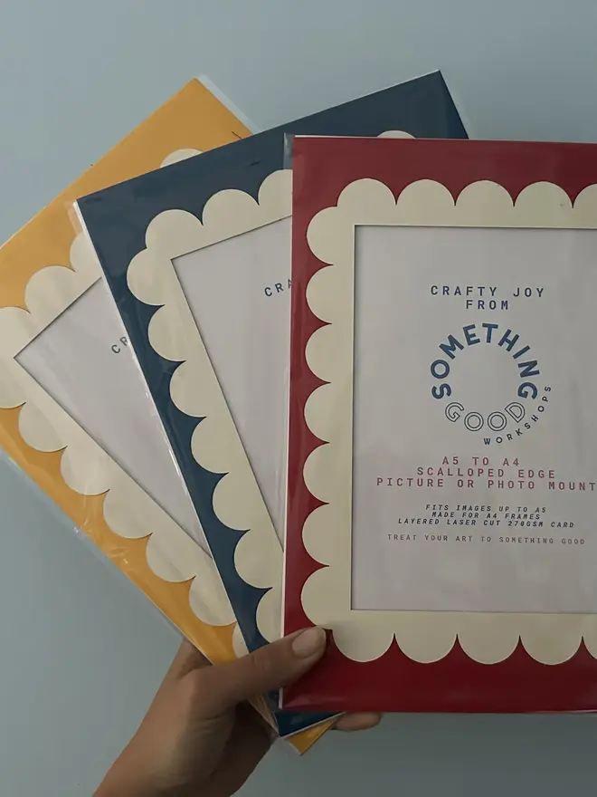 Scallop Edged A5 / A4 photo mount. red blue and yellow variants shown against grey background. 